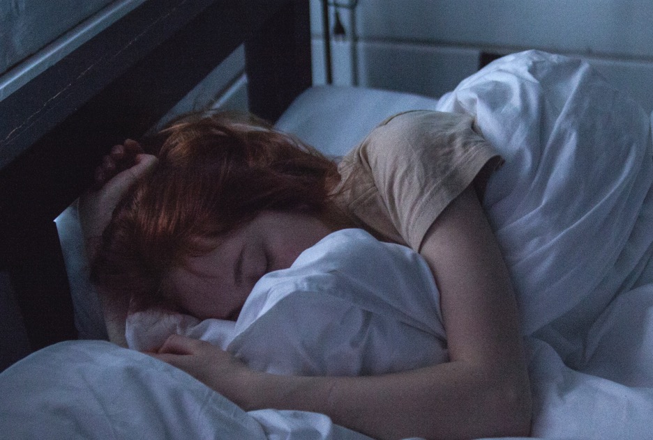 Young woman sleeping in her bed at home