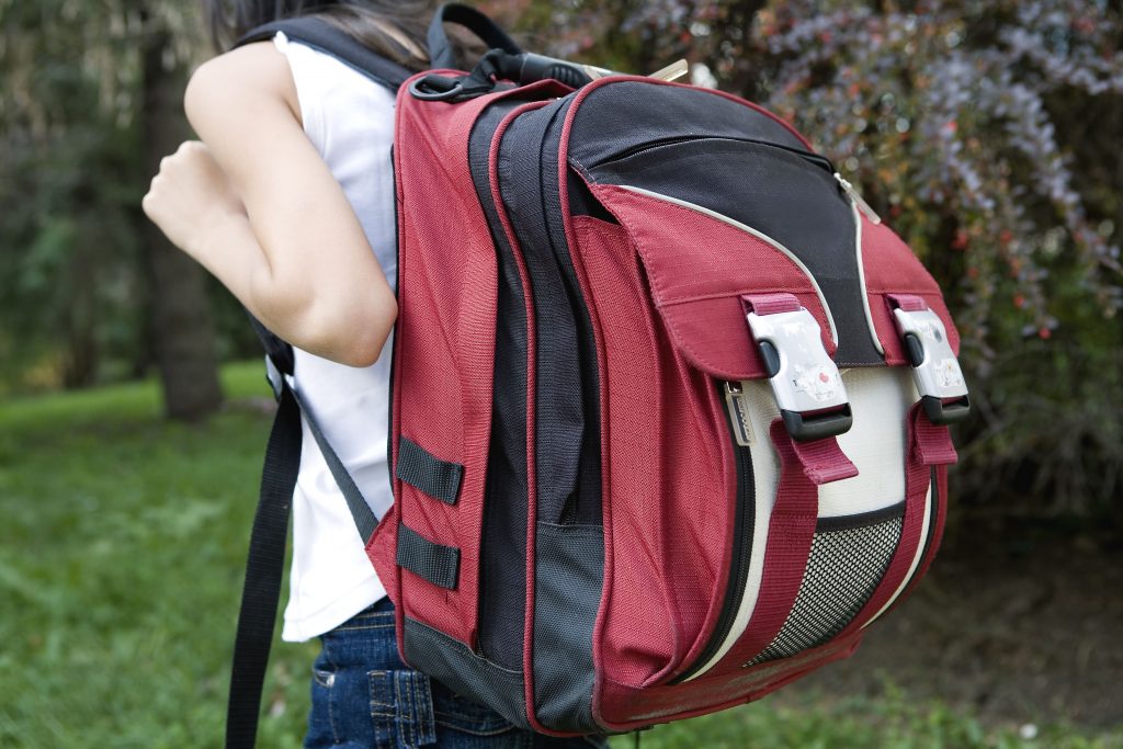 Girl with a big backpack walking down the street