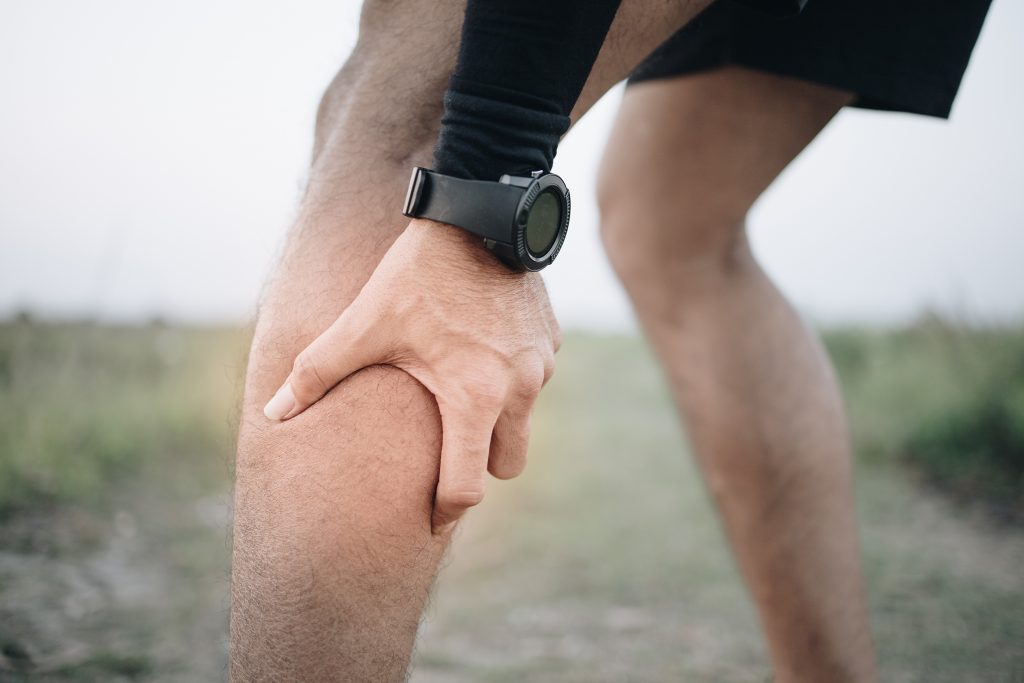 Male runner suffering with calf pain outdoor
