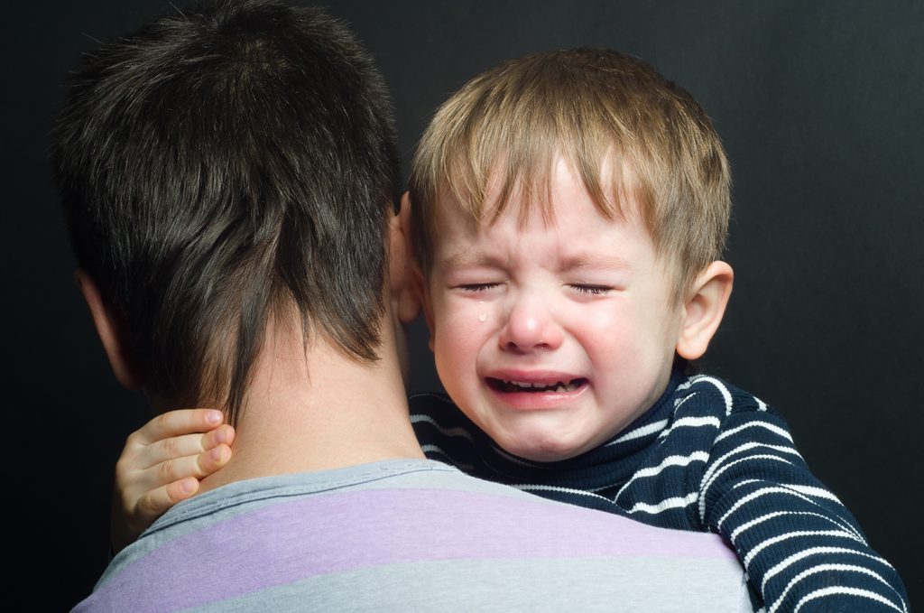 Child is being carried while crying in pain