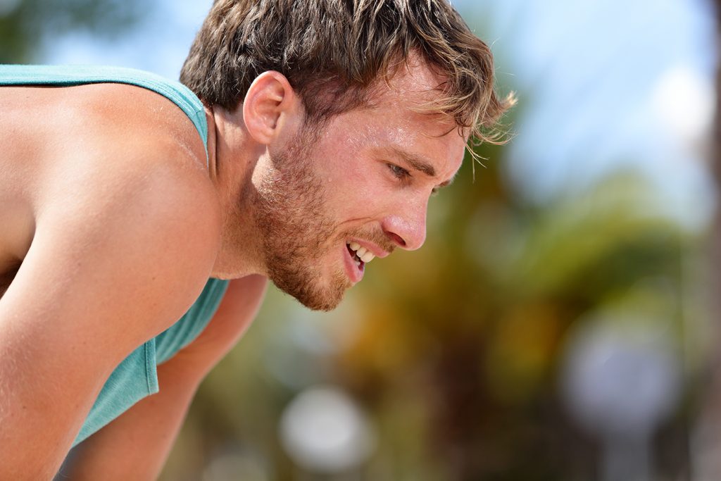 Tired exhausted man runner sweating after workout