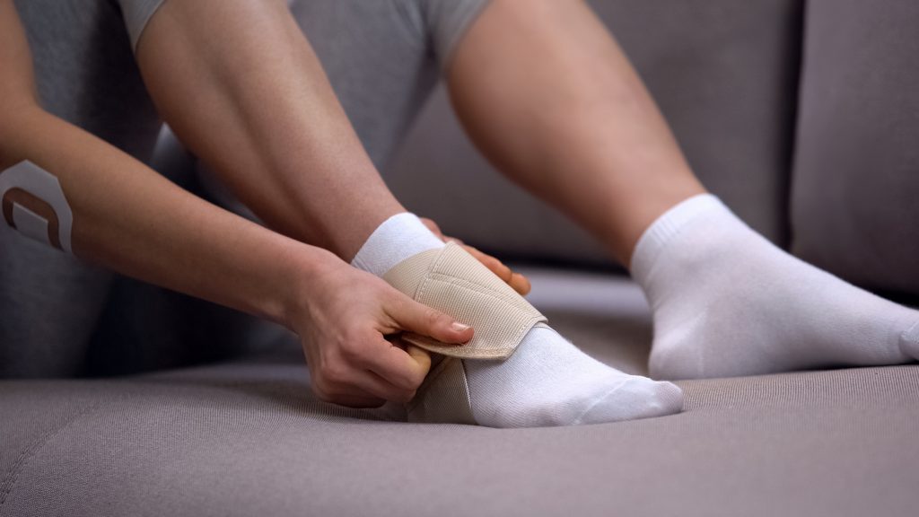 Lady fixing two-strap ankle wrap in proper position