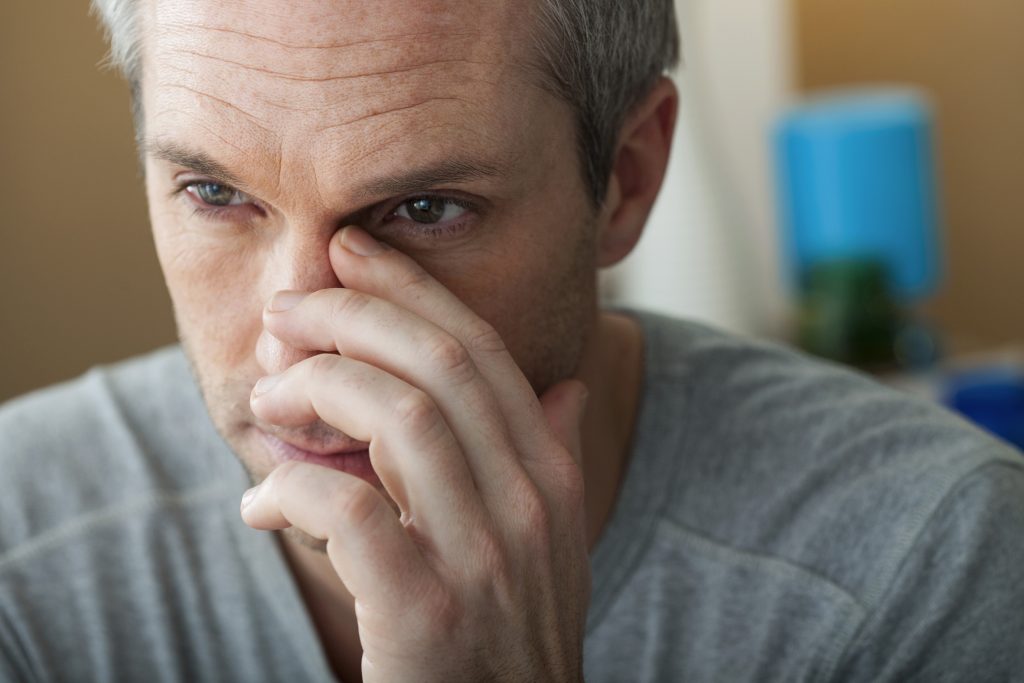 Frustrated man touching his nose