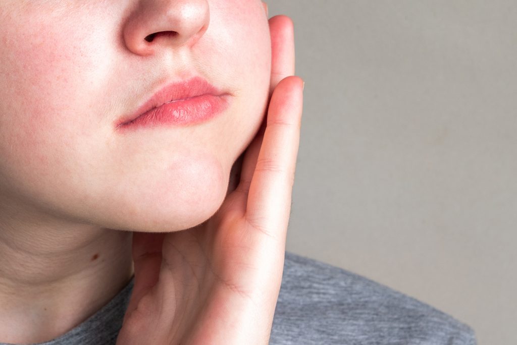 Young woman touching her cheek